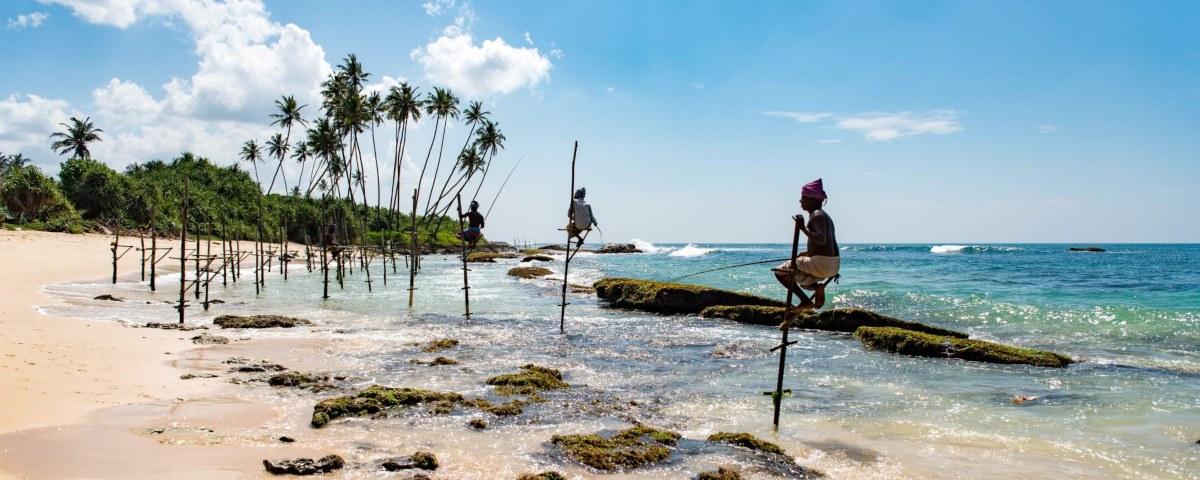 Sri Lanka beach with fishermen on stilts