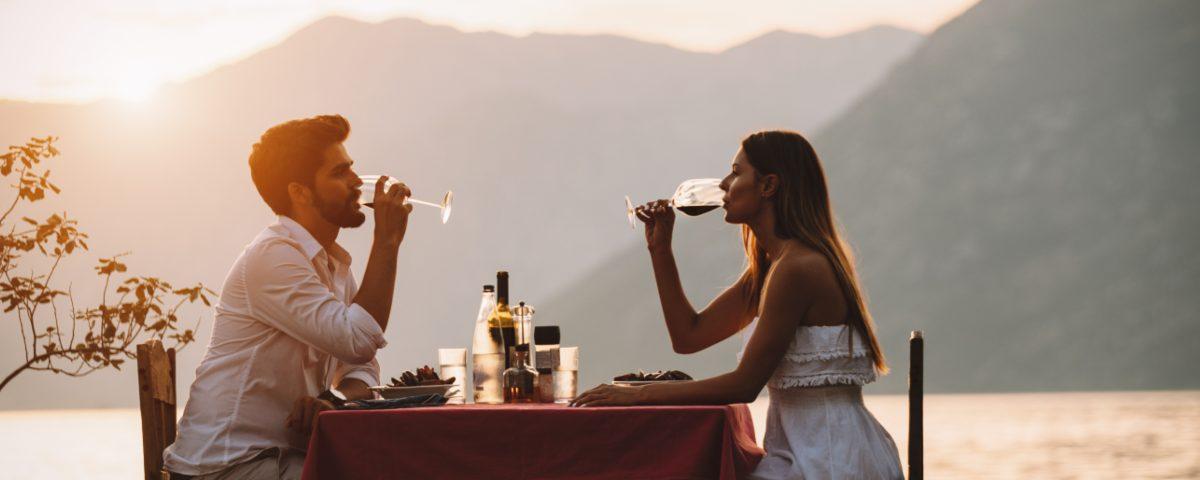 Couple having dinner by the sea at sunset